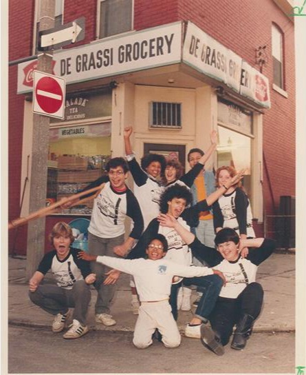 The Kids of Degrassi Street cast standing and kneeling outside the Degrassi Grocery storefront in Toronto, celebrating together in a 1985 Toronto Star photo by Keith Beaty.